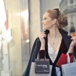 Smiling woman holding shopping bags in a city, enjoying a day of shopping.